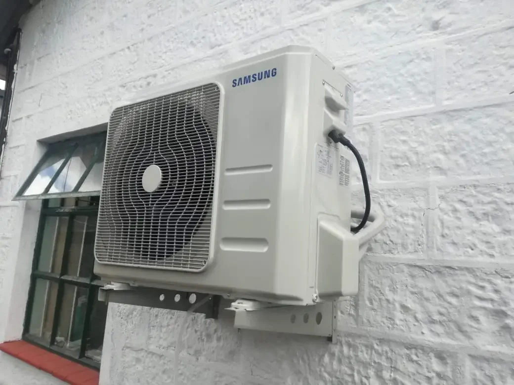 HVAC technician diagnosing an indoor air conditioning unit